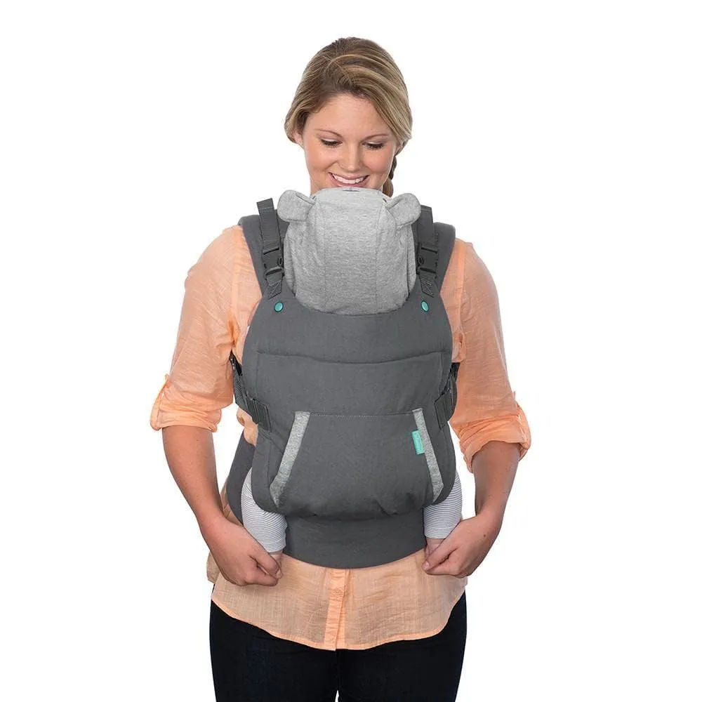 Mother safely wearing baby in an ergonomic carrier with correct M-position